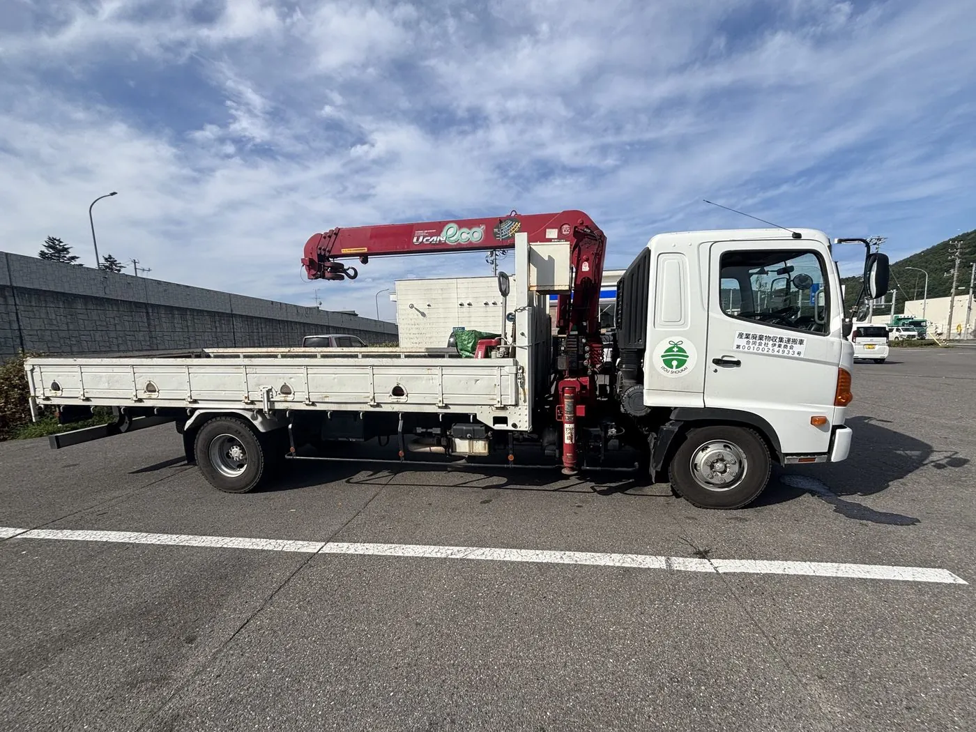 社名と許可番号の入った、クレーン付きの産業廃棄物収集運搬車